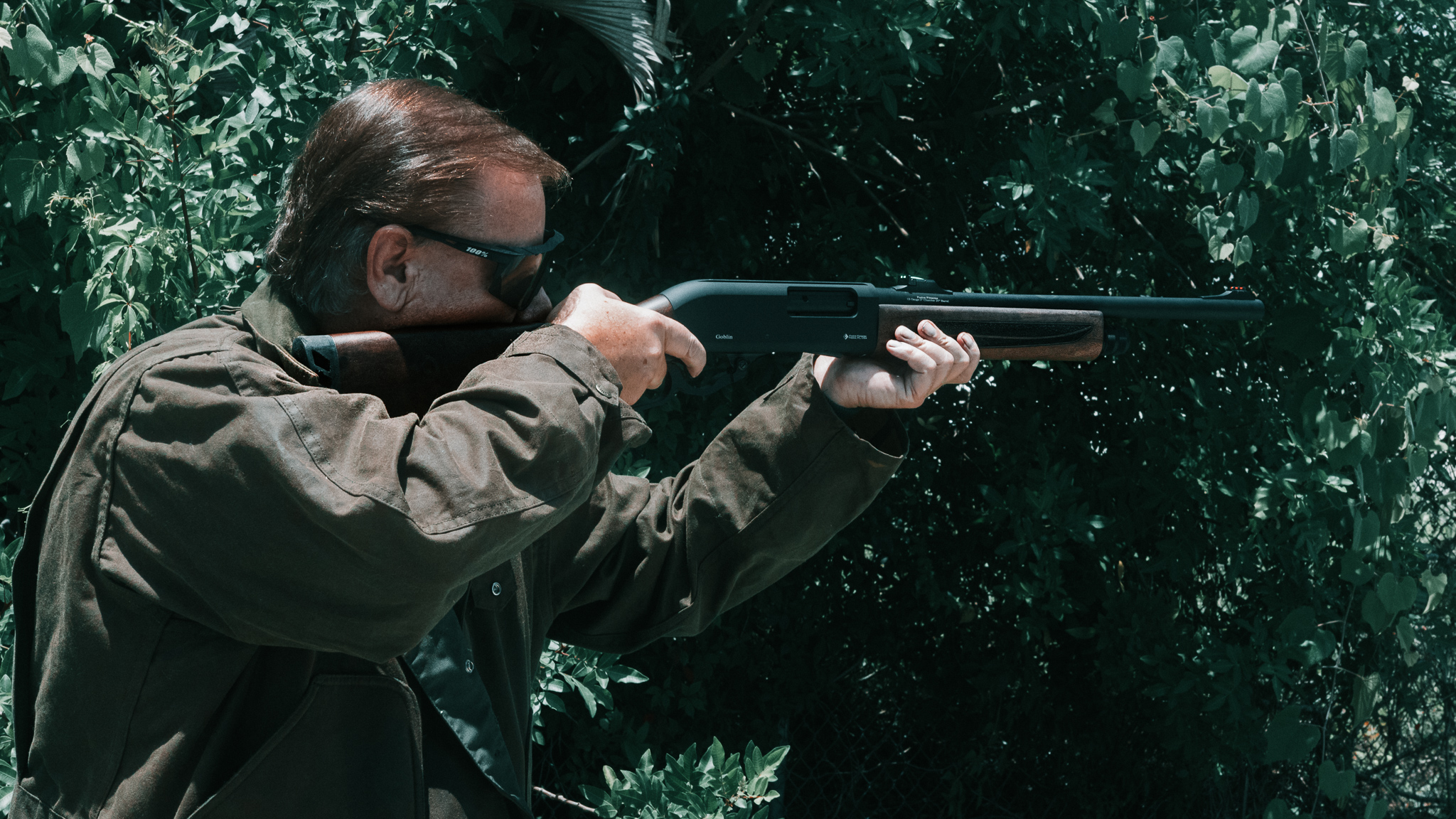 A person holding a pump action shotgun for home defense